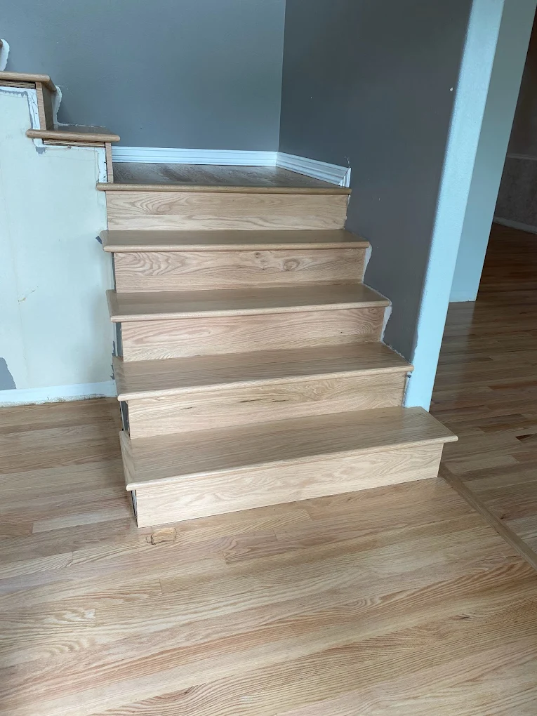Refinished red oak stair treads and risers meeting a newly sanded floor in a Portland home